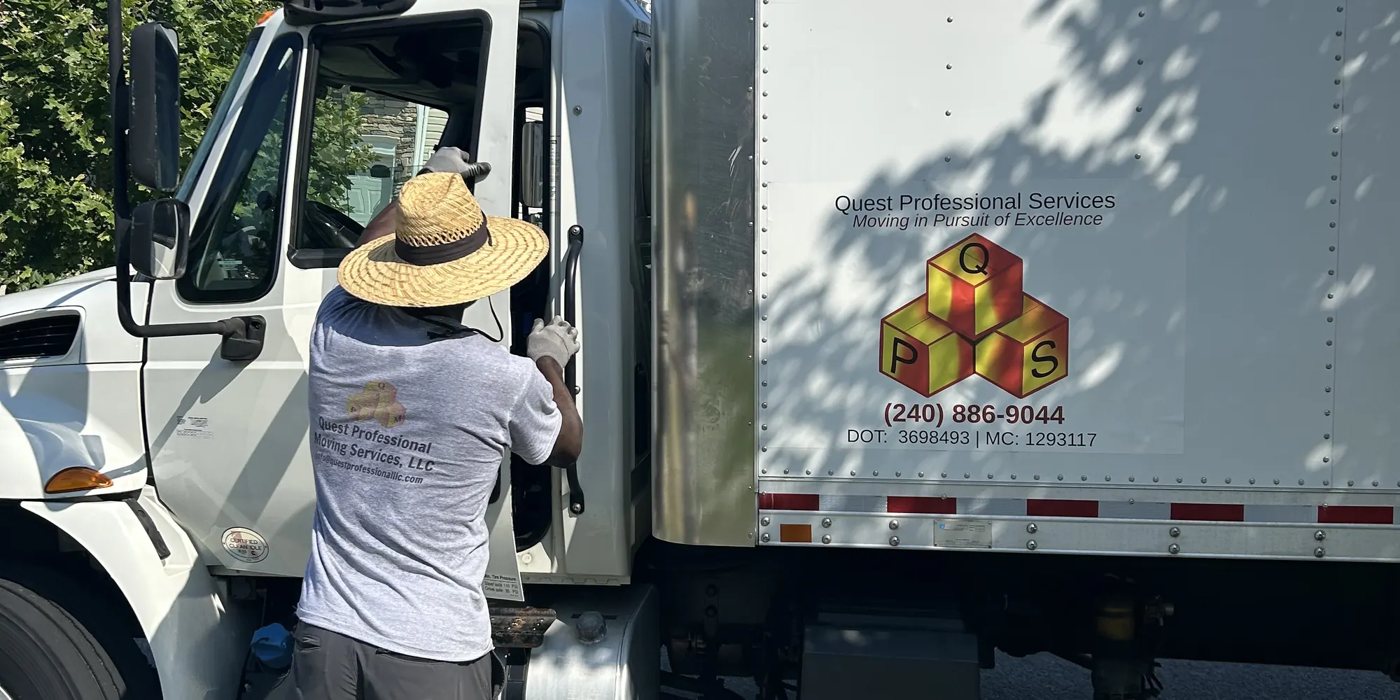 Quest crew member at the cab of a branded Quest box truck