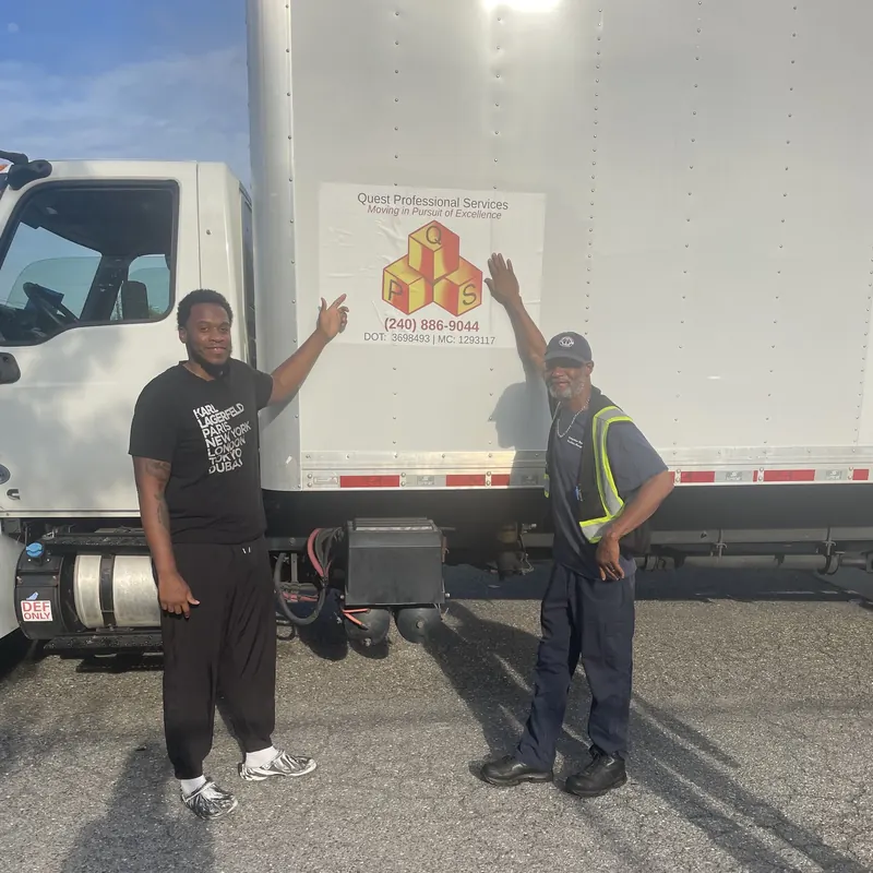 Quest crew members with a branded box truck
