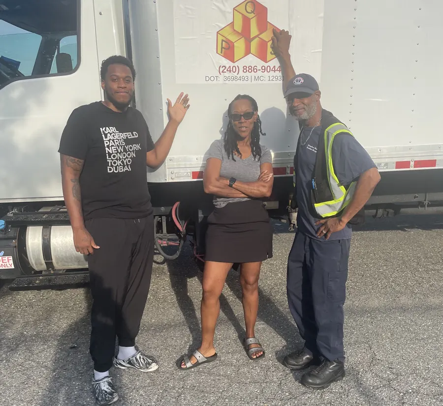 The Quest Professional Services team in front of a company box truck